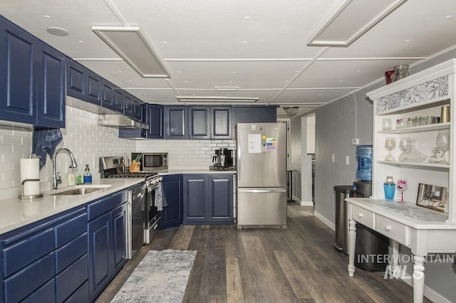 kitchen with tasteful backsplash, a sink, light countertops, appliances with stainless steel finishes, and blue cabinets