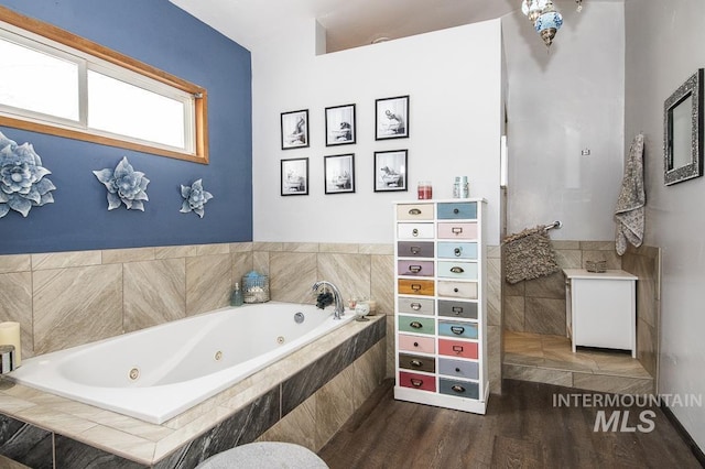 bathroom featuring a tub with jets and wood finished floors