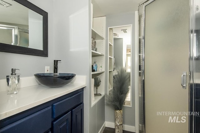 full bath with a stall shower, vanity, and visible vents