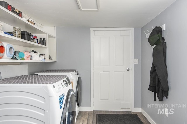 clothes washing area with laundry area, dark wood-style flooring, baseboards, and washing machine and dryer