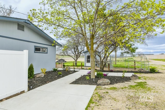 view of home's community featuring fence and an outdoor structure