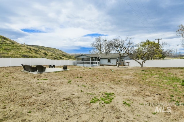 back of house featuring a patio area, a fenced backyard, and a sunroom