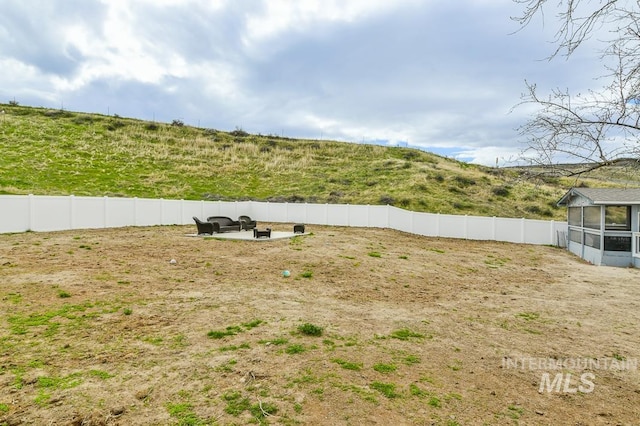 view of yard featuring fence and an outdoor fire pit