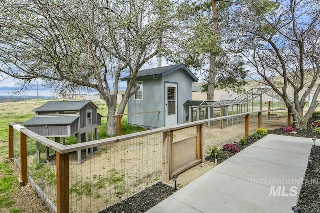 exterior space featuring exterior structure, an outbuilding, and fence