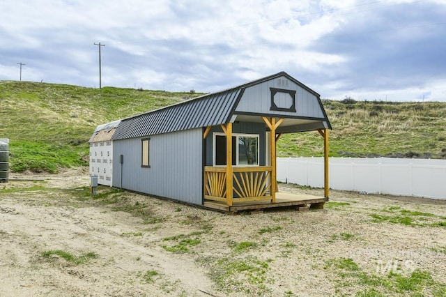 view of outbuilding with fence and an outbuilding