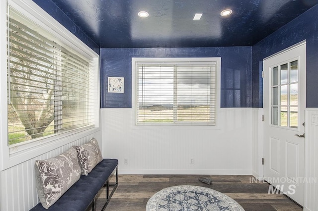 living area with recessed lighting, a wainscoted wall, and wood finished floors