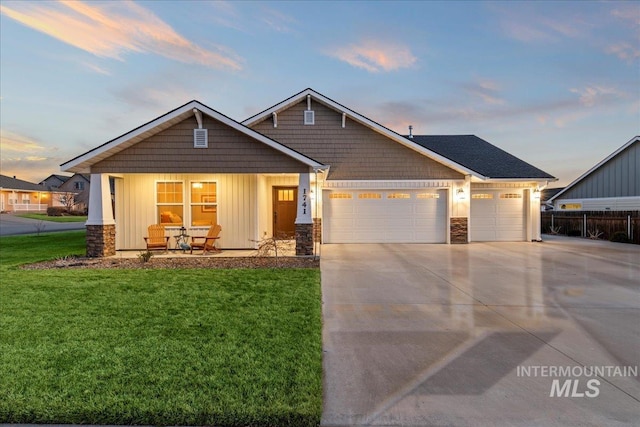 craftsman-style home featuring a lawn, driveway, stone siding, board and batten siding, and an attached garage