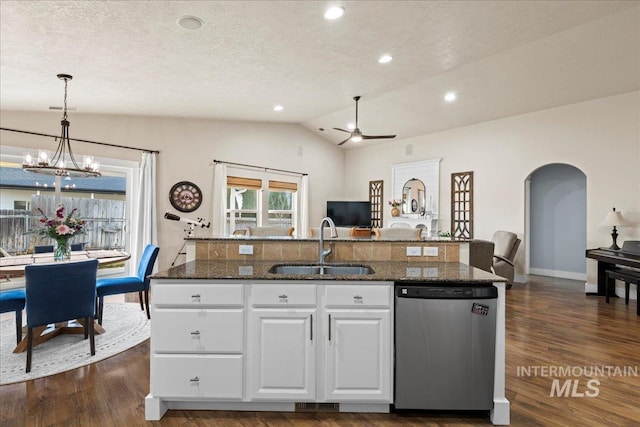 kitchen with lofted ceiling, arched walkways, a sink, dark wood-type flooring, and stainless steel dishwasher