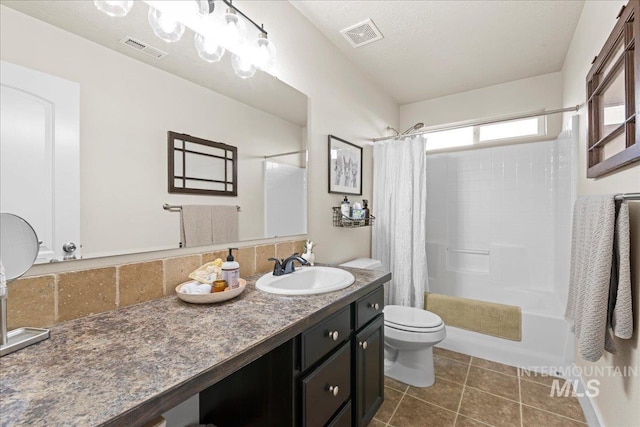 bathroom featuring tile patterned flooring, toilet, visible vents, and shower / tub combo with curtain