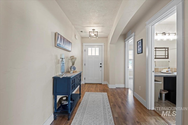 entrance foyer featuring wood finished floors, baseboards, and a textured ceiling