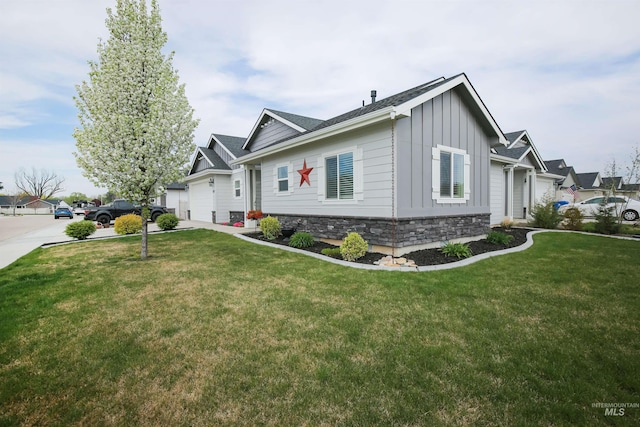view of side of home with board and batten siding, a garage, stone siding, and a lawn