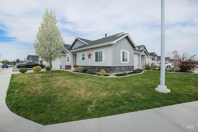 view of side of home featuring a garage, board and batten siding, stone siding, and a lawn