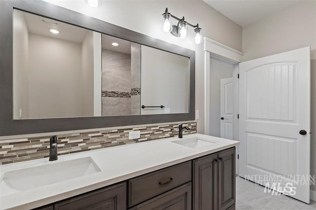 bathroom with a sink, tasteful backsplash, and double vanity