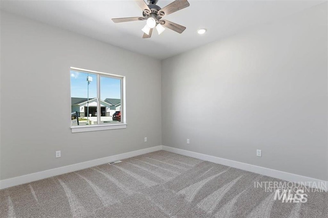 carpeted empty room featuring visible vents, baseboards, and a ceiling fan