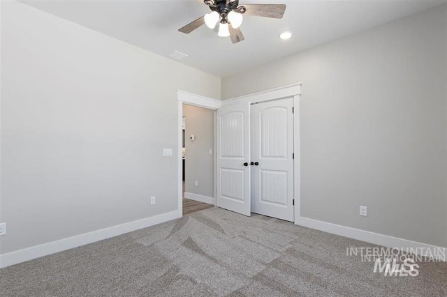 unfurnished bedroom featuring carpet floors, baseboards, a ceiling fan, and a closet