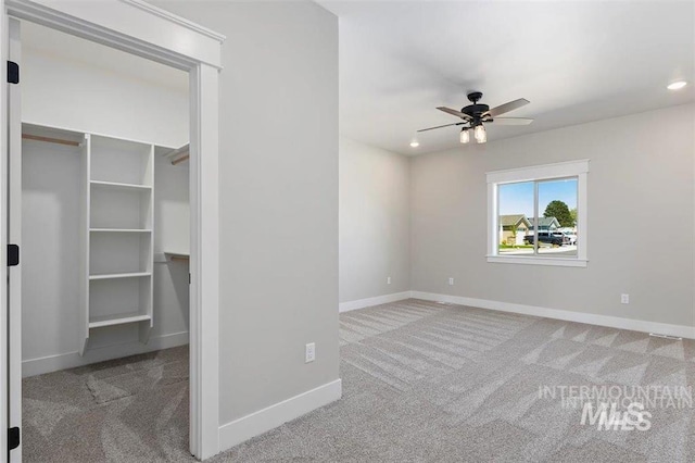unfurnished bedroom with a closet, baseboards, a spacious closet, carpet floors, and recessed lighting