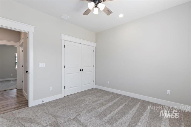 unfurnished bedroom with a closet, baseboards, recessed lighting, ceiling fan, and carpet