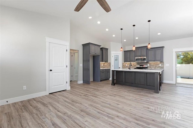 kitchen with light countertops, ceiling fan, gray cabinetry, stainless steel appliances, and decorative backsplash