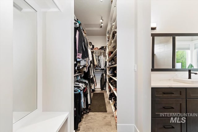 walk in closet featuring a sink