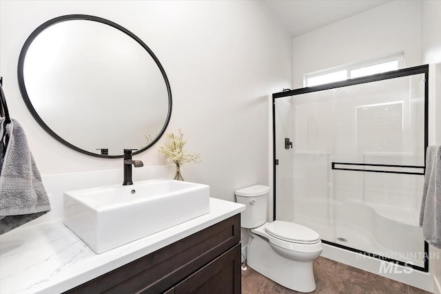 bathroom featuring toilet, a stall shower, and vanity