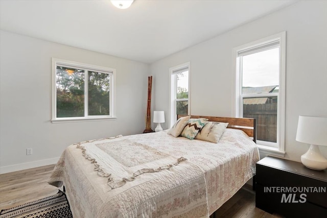 bedroom featuring wood finished floors and baseboards