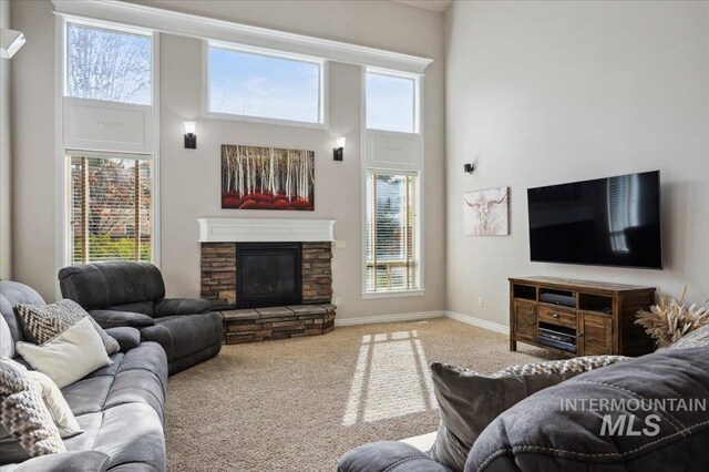4824 S Longmoor Ave, Boise, ID 83709 - carpeted living room with plenty of natural light, a towering ceiling, and a stone fireplace