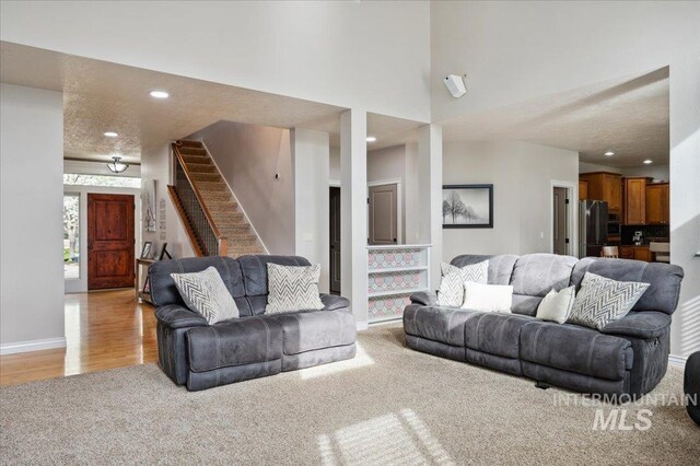 4824 S Longmoor Ave, Boise, ID 83709 - living area with baseboards, light wood-type flooring, recessed lighting, stairway, and a towering ceiling