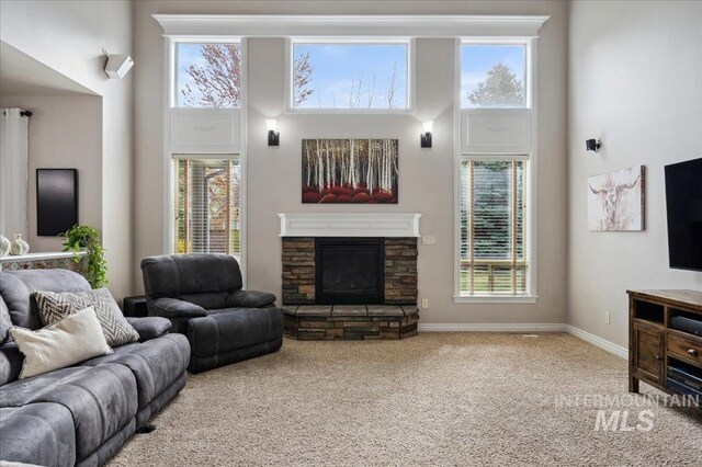 4824 S Longmoor Ave, Boise, ID 83709 - living room featuring carpet, a stone fireplace, a high ceiling, and baseboards