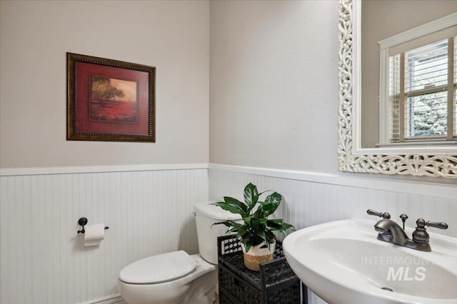 4824 S Longmoor Ave, Boise, ID 83709 - half bathroom with toilet, a sink, and a wainscoted wall