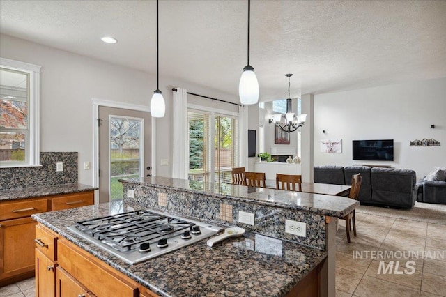 4824 S Longmoor Ave, Boise, ID 83709 - kitchen featuring open floor plan, stainless steel gas stovetop, an inviting chandelier, and a kitchen island