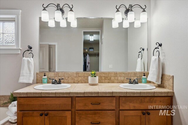 4824 S Longmoor Ave, Boise, ID 83709 - bathroom featuring double vanity, decorative backsplash, and a sink