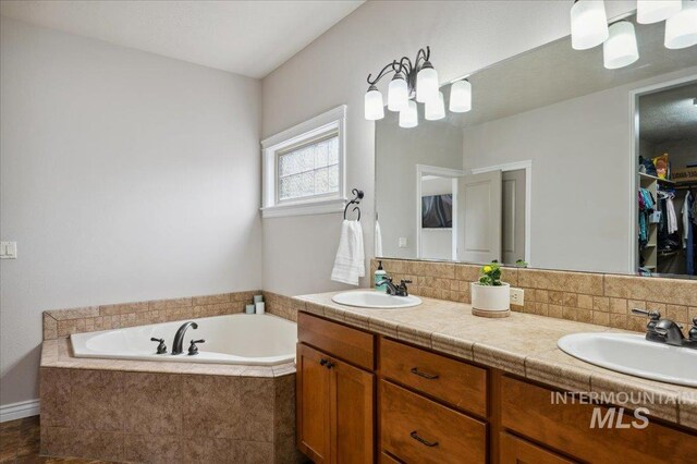 4824 S Longmoor Ave, Boise, ID 83709 - bathroom featuring a garden tub, double vanity, a sink, and a walk in closet