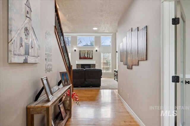 4824 S Longmoor Ave, Boise, ID 83709 - corridor with baseboards, light wood finished floors, stairway, and a textured ceiling
