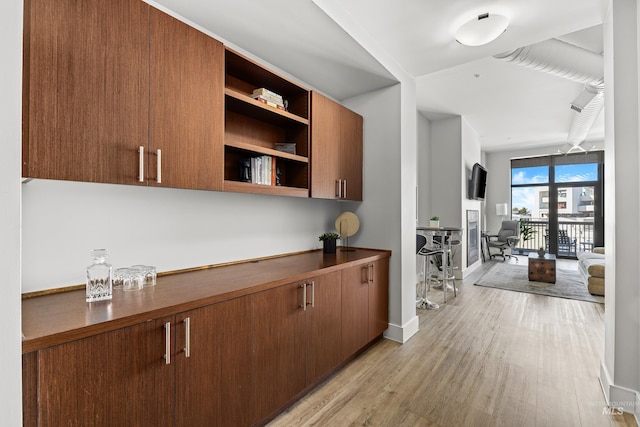 hall with light wood-type flooring and baseboards