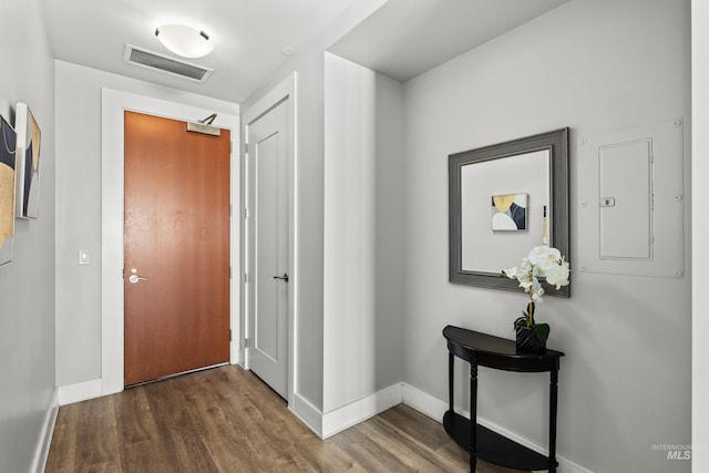 interior space with baseboards, electric panel, visible vents, and wood finished floors