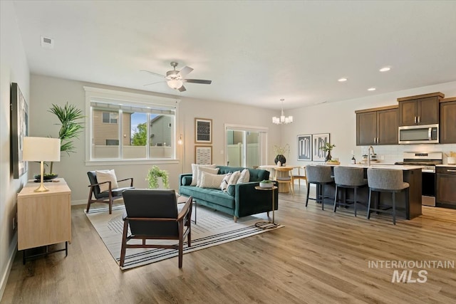 2219 E Danzee Dr, Boise, ID 83716 - living room featuring a chandelier, light wood finished floors, recessed lighting, ceiling fan, and baseboards