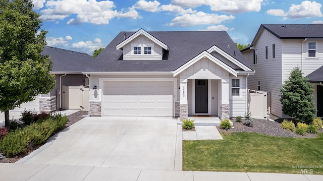 view of front facade featuring board and batten siding, concrete driveway, stone siding, a shingled roof, and an attached garage