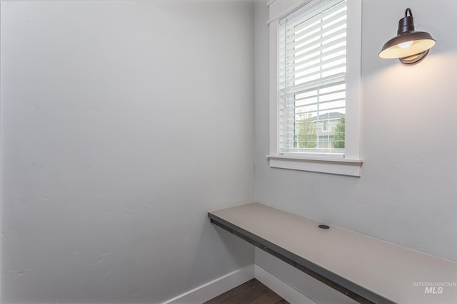 unfurnished office featuring plenty of natural light, baseboards, and dark wood-type flooring