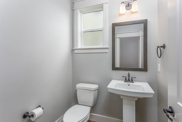 bathroom with toilet and baseboards