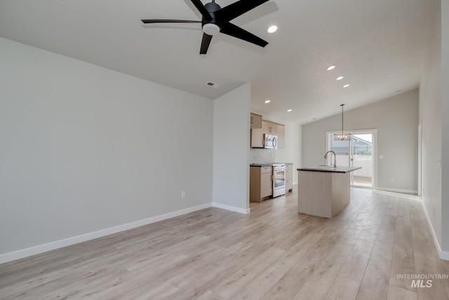 unfurnished living room with baseboards, a sink, ceiling fan with notable chandelier, vaulted ceiling, and light wood-style floors