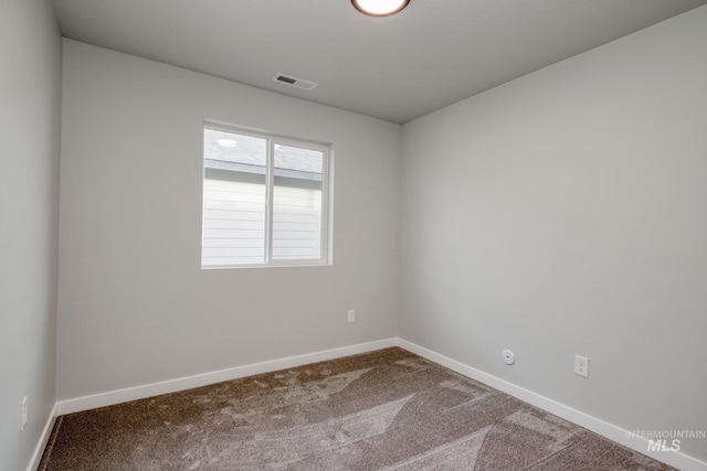 carpeted spare room featuring visible vents and baseboards
