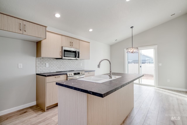 kitchen featuring a sink, backsplash, dark countertops, stainless steel appliances, and light wood-type flooring