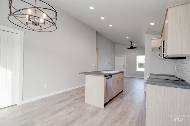 kitchen featuring light wood finished floors, an island with sink, a sink, stainless steel appliances, and lofted ceiling