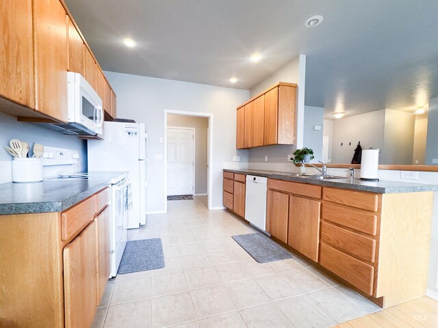 1937 E Vandal Dr, Moscow, ID 83843 - kitchen featuring white appliances, a sink, a peninsula, dark countertops, and baseboards