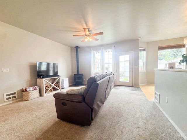 1937 E Vandal Dr, Moscow, ID 83843 - living area with light carpet, a wood stove, a ceiling fan, and baseboards