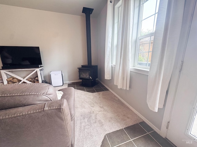 1937 E Vandal Dr, Moscow, ID 83843 - living area featuring tile patterned flooring, a wood stove, baseboards, and carpet flooring