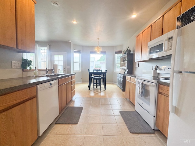 1937 E Vandal Dr, Moscow, ID 83843 - kitchen with white appliances, a sink, brown cabinetry, dark countertops, and light tile patterned floors