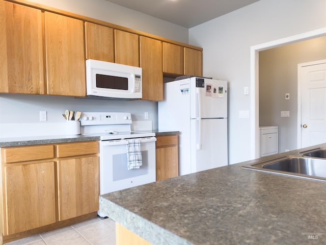 1937 E Vandal Dr, Moscow, ID 83843 - kitchen featuring white appliances, dark countertops, light tile patterned floors, a sink, and brown cabinets