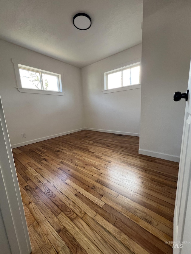 317 Baker Dr, Mountain Home, ID 83647 - unfurnished room with wood-type flooring, healthy amount of natural light, and baseboards