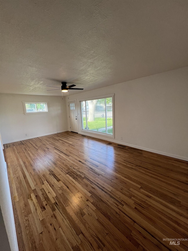 317 Baker Dr, Mountain Home, ID 83647 - unfurnished room with wood finished floors, plenty of natural light, a textured ceiling, baseboards, and a ceiling fan